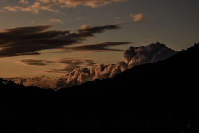 Low angle view of silhouette mountain against dramatic sky