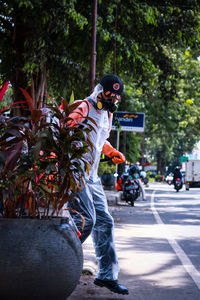 Man standing by street in city