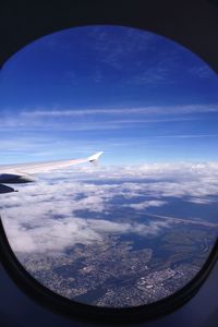 Aerial view of clouds over landscape seen from airplane window