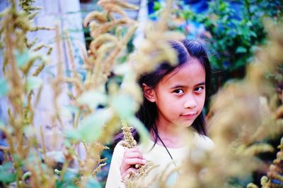 Portrait of young woman against plants