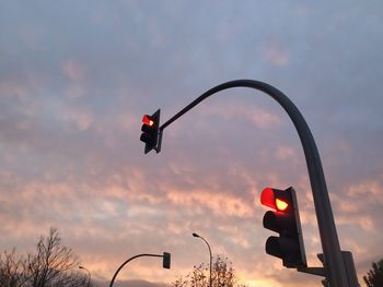 Low angle view of road sign against sky during sunset