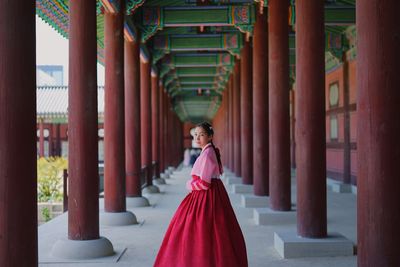 Portrait of woman standing at corridor