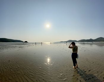 Full length of man standing on beach against sky