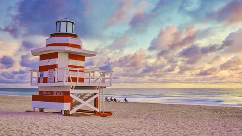 Lighthouse by sea against sky