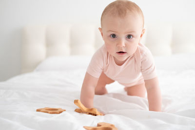 Portrait of cute baby girl on bed