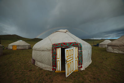 Tent on field against cloudy sky