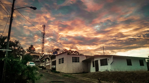 Houses against sky at sunset