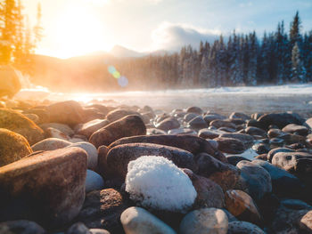 Stones on rocks at shore against sky