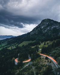 Light trail on mountain road against sky