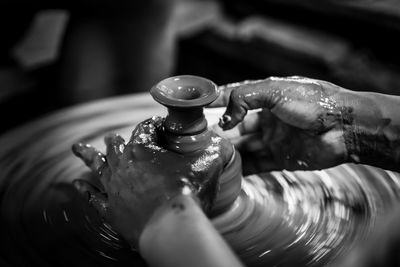 Cropped hands of person working on pottery wheel