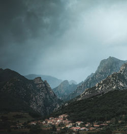 Scenic view of townscape by mountains against sky