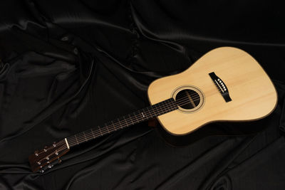 High angle view of guitar on bed