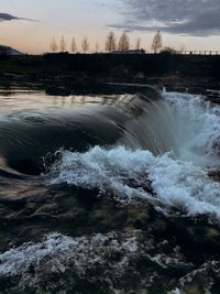 Scenic view of river flowing against sky