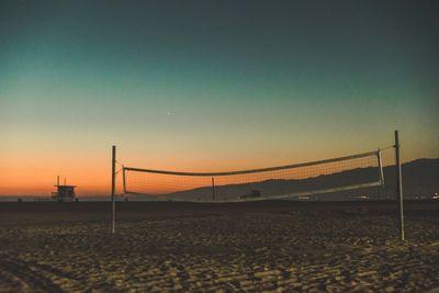 Scenic view of beach against clear sky during sunset