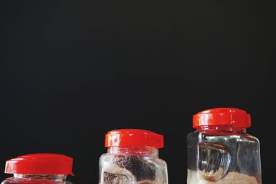 Close-up of cropped jars over black background