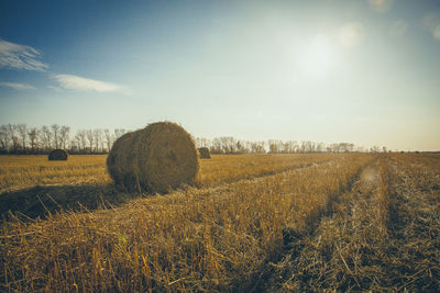 Hay bales on field against sky