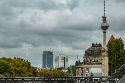 Buildings in city against cloudy sky