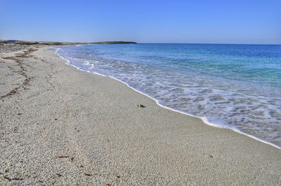 Scenic view of beach against clear blue sky