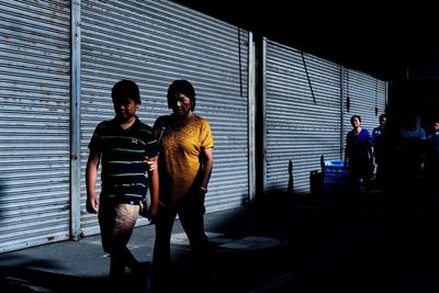 Full length portrait of friends standing against window