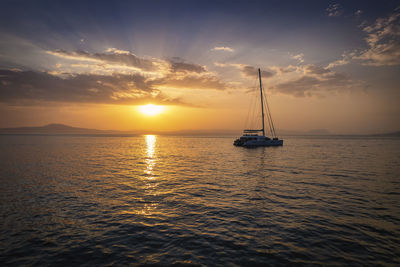 Sailboat on sea against sky during sunset