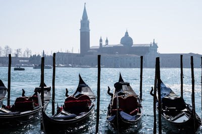 Boats moored in sea with city in background