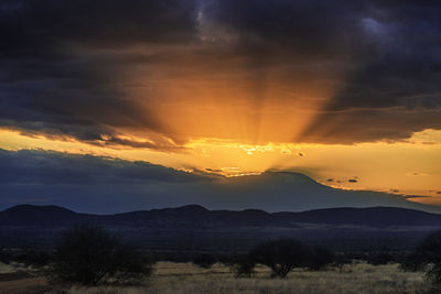 Scenic view of silhouette mountains against sky at sunset