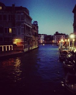 Canal in city against sky