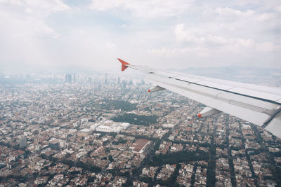 Cropped image of airplane flying over cityscape 