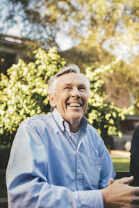 Smiling senior man looking away at outdoors cafe