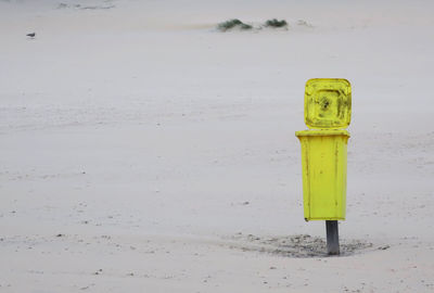 Close-up of mailbox on sand at beach during winter