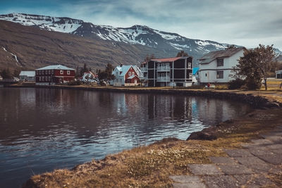 Houses by lake against mountain