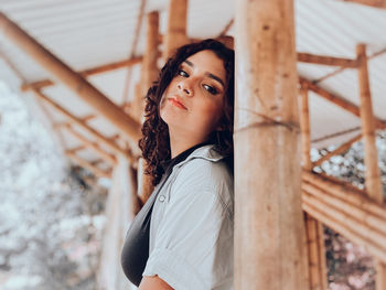 Portrait of woman standing against railing