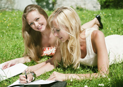 Happy young woman lying down on field