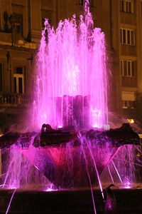 Water splashing in fountain at night