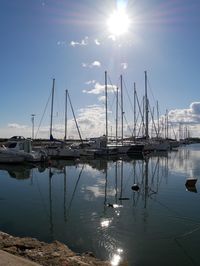 Sailboats moored on sea against sky