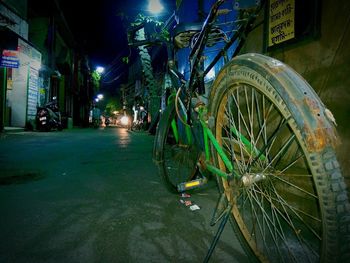 Bicycle parked on street in city at night