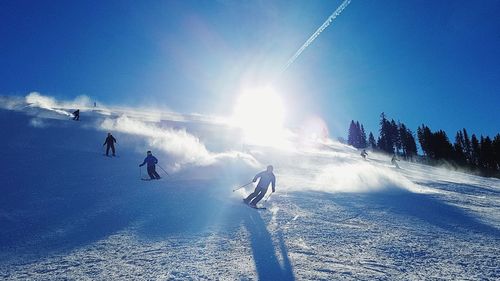 People skiing on snowcapped mountain against sky