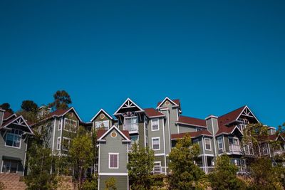 Low angle view of buildings against clear blue sky