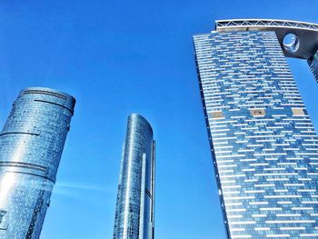 Low angle view of modern buildings against clear blue sky