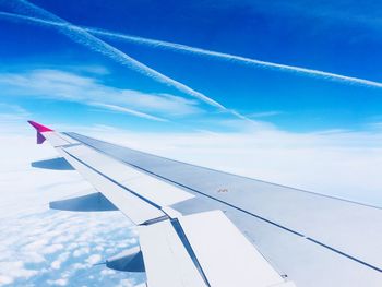 Low angle view of airplane flying against blue sky