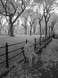 Full length of man sitting on bench at park during autumn