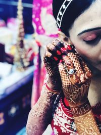 Close-up of bride wearing jewelry at home