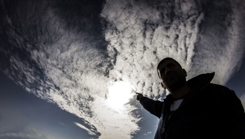 Low angle view of silhouette man standing against sky