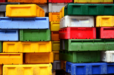 Full frame shot of stacked colorful plastic containers at fish market