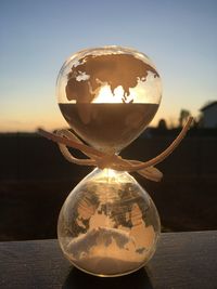 Close-up of crystal ball on table against sky during sunset