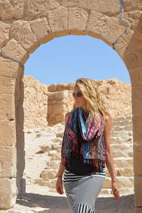 Woman wearing sunglasses standing against clear sky