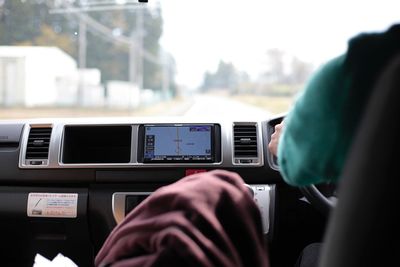 Close-up of hand using mobile phone in bus