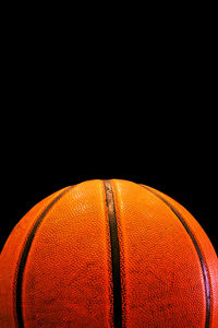 Close-up of basketball hoop against black background