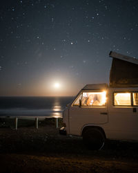 Car on beach against sky at night