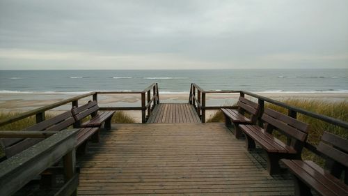 Boardwalk on beach against sky